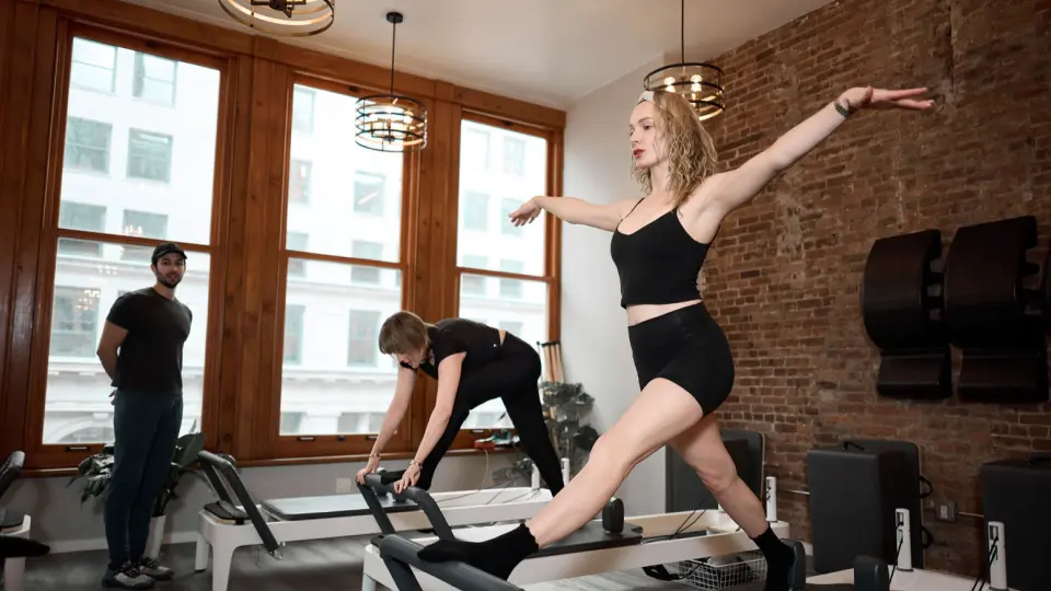Instructor guiding a student during a private reformer Pilates session at BK Pilates Flatiron