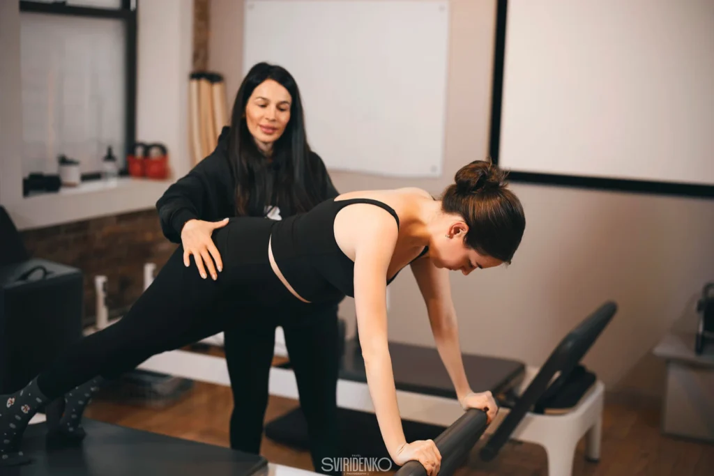 BK Pilates instructor demonstrating reformer technique in studio