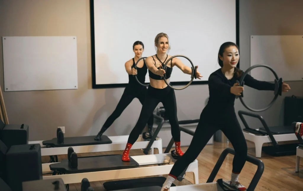 Small group performing standing ring exercises in a dynamic 30 minute Pilates class to build balance and strength