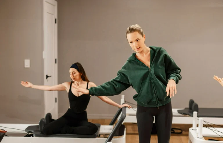 Professional Pilates instructor guiding a client through a personalized workout for a 12-week health transformation