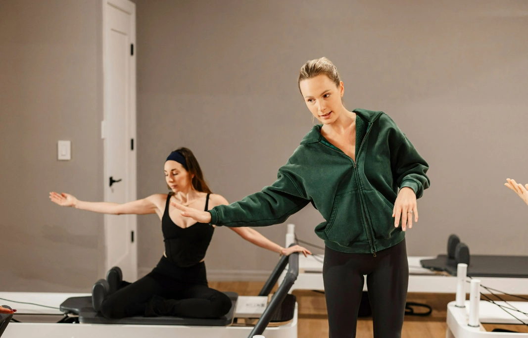 Professional Pilates instructor guiding a client through a personalized workout for a 12-week health transformation