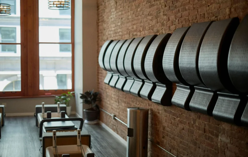 Pilates studio interior with reformers and exposed brick wall