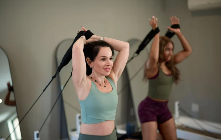 Fitness enthusiasts practicing resistance training on Pilates reformers to build a strong and functional core.