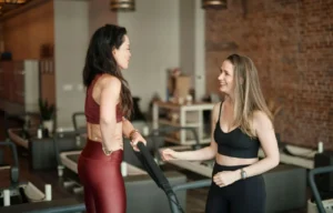 A professional instructor at BK Pilates Flatiron discussing the benefits of movement for stress relief with a client