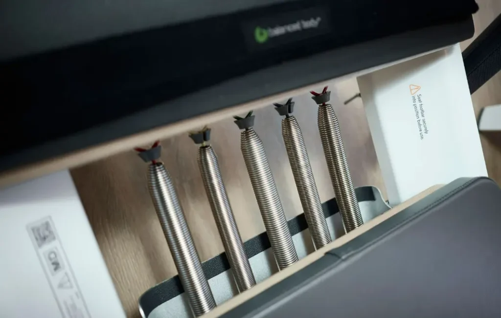Close-up of high-quality metal resistance springs on a Balanced Body reformer at a BK Pilates studio location.