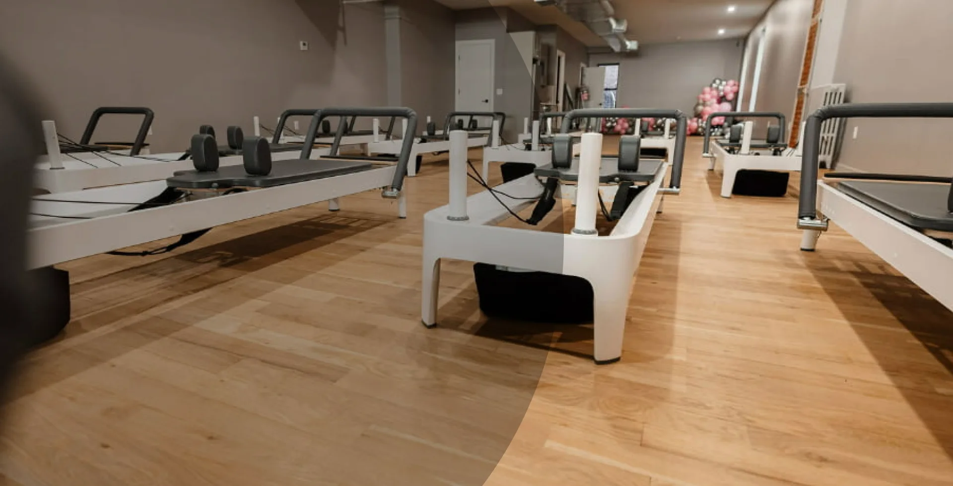 An empty Pilates studio with multiple reformers, ready for a class