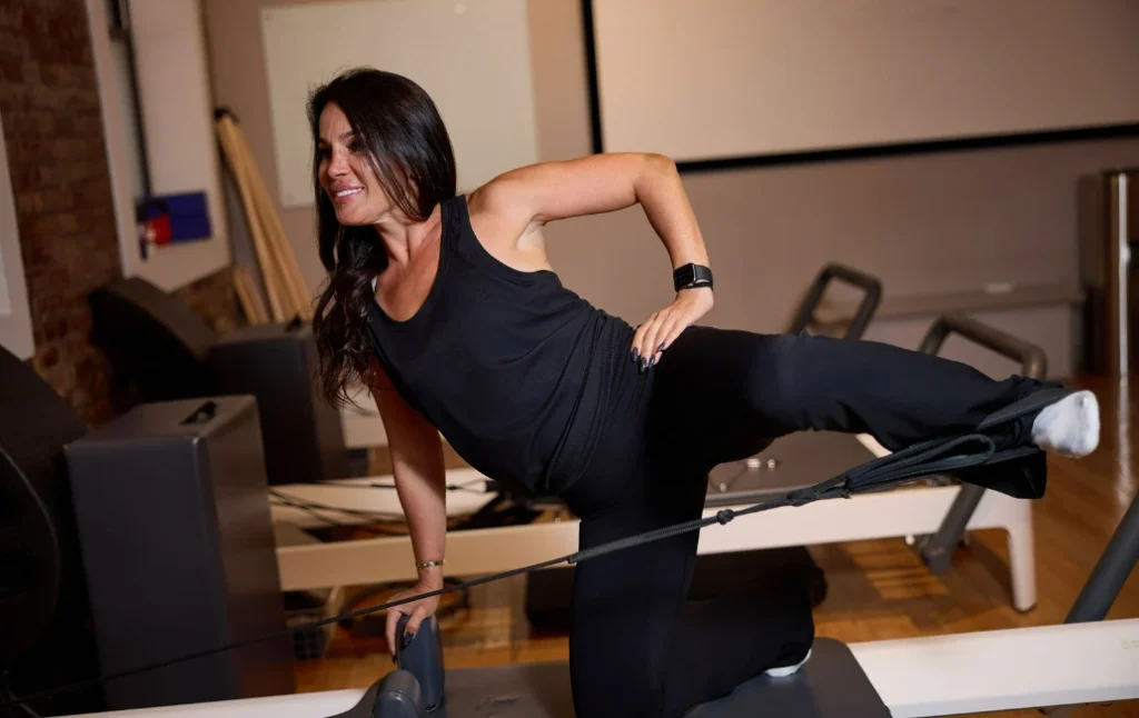 A woman practicing controlled resistance movements on a reformer machine to build lean muscle without bulking at BK Pilates