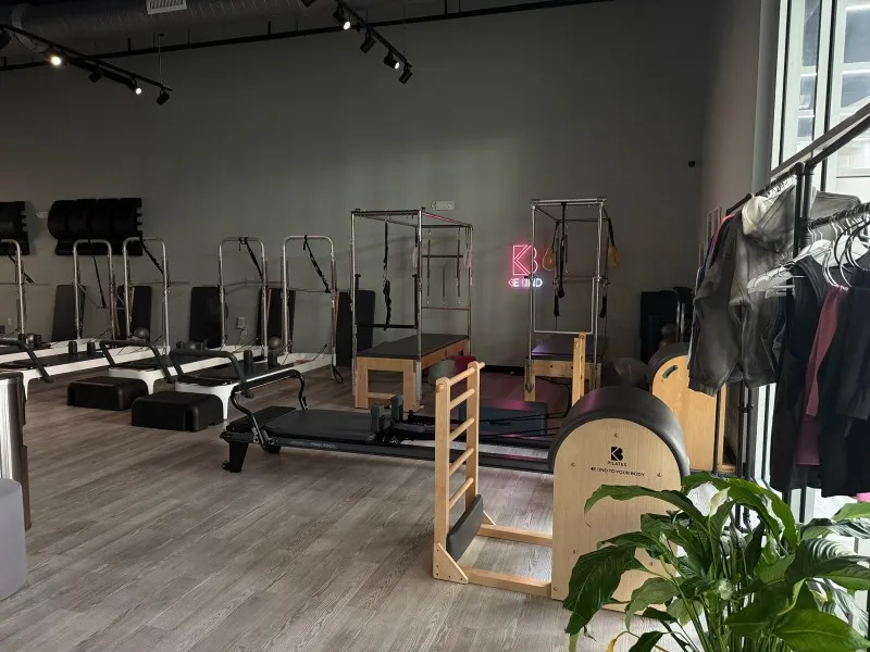 Rows of high-end white and black Pilates reformer machines with jump boards ready for a group session at BK Pilates studio