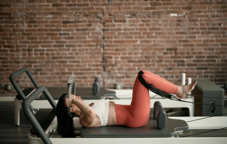 Woman engaging her obliques during a reformer Pilates exercise on the reformer carriage
