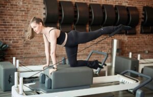 Athlete performing low impact reformer pilates training in an NYC studio