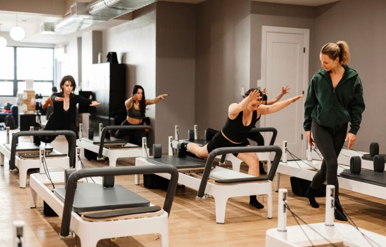 Instructor guiding a reformer Pilates class at BK Pilates, comparing Pilates vs yoga training styles