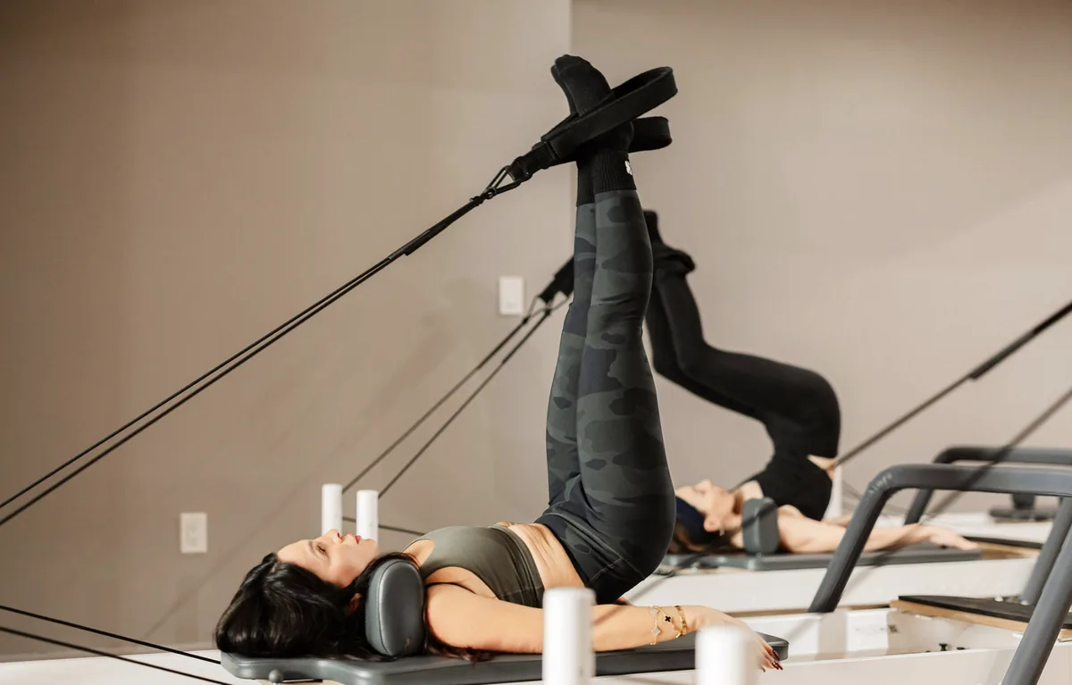Women doing a reformer Pilates class with leg straps at BK Pilates studio in Brooklyn